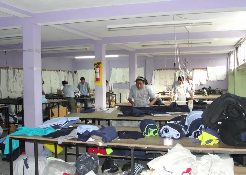 Área de corte del taller de Uniformes OR con mesas de tela y piezas cortadas